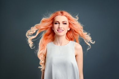 Beautiful woman with long orange hair on grey background