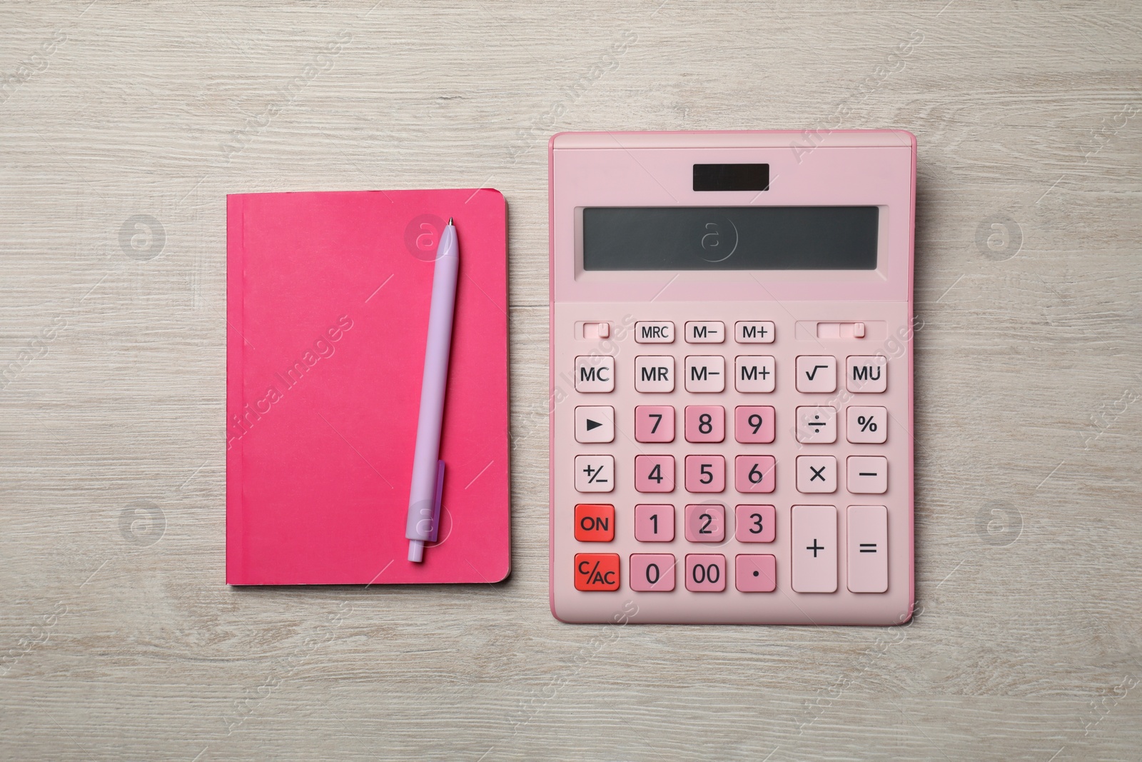 Photo of Calculator and office stationery on light wooden table, flat lay