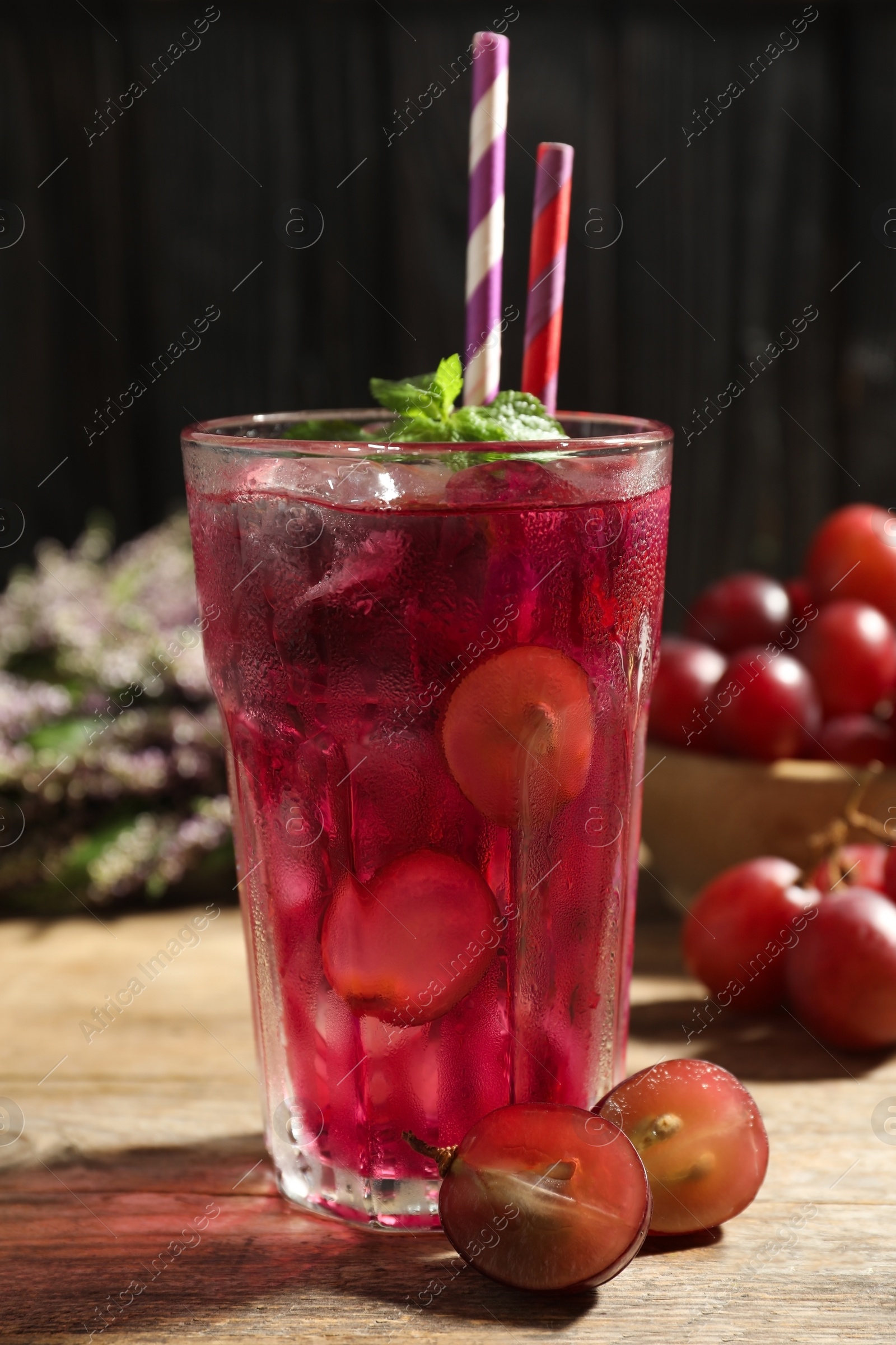 Photo of Delicious grape soda water with mint and berries on wooden table. Refreshing drink