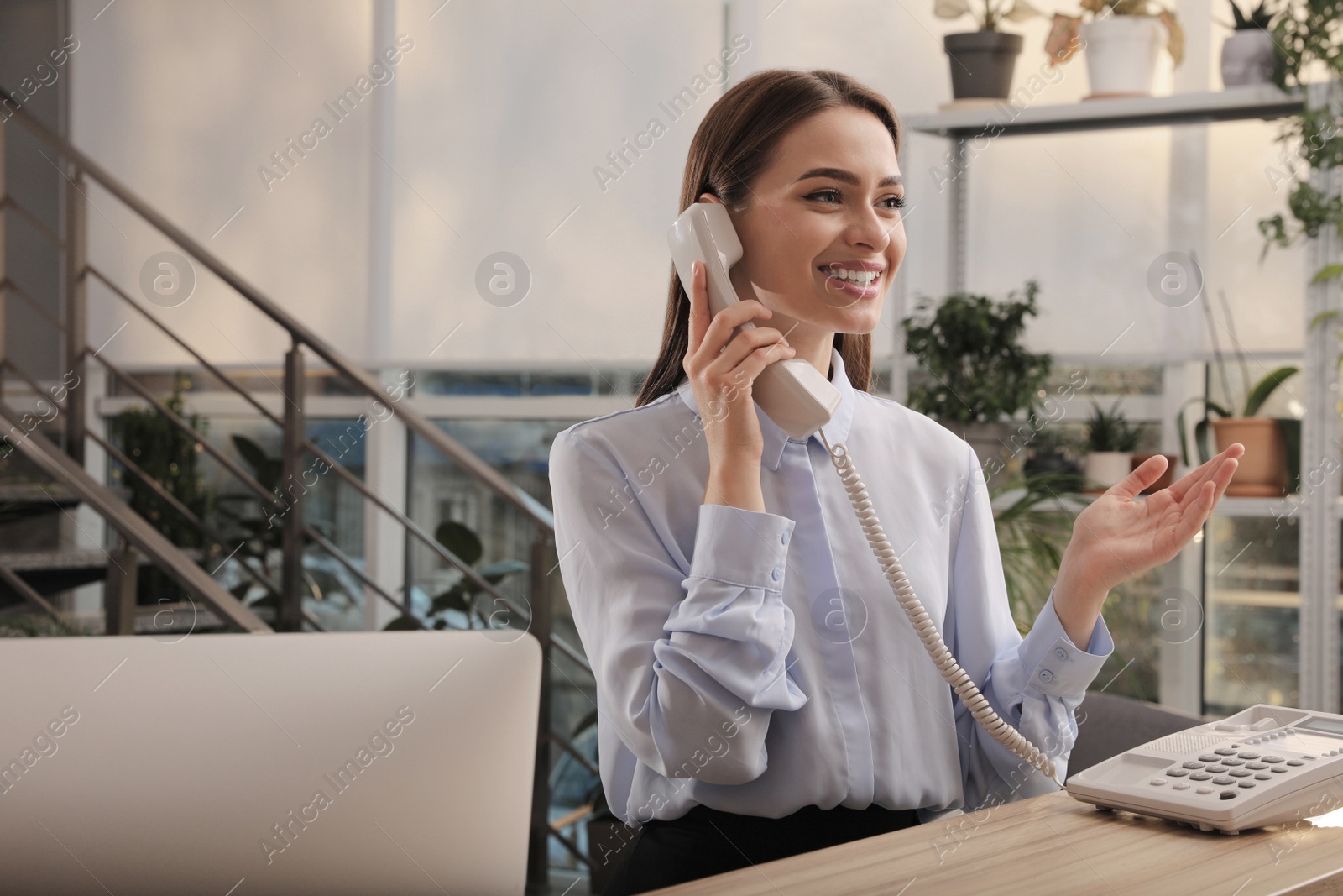 Photo of Female receptionist talking on phone at workplace