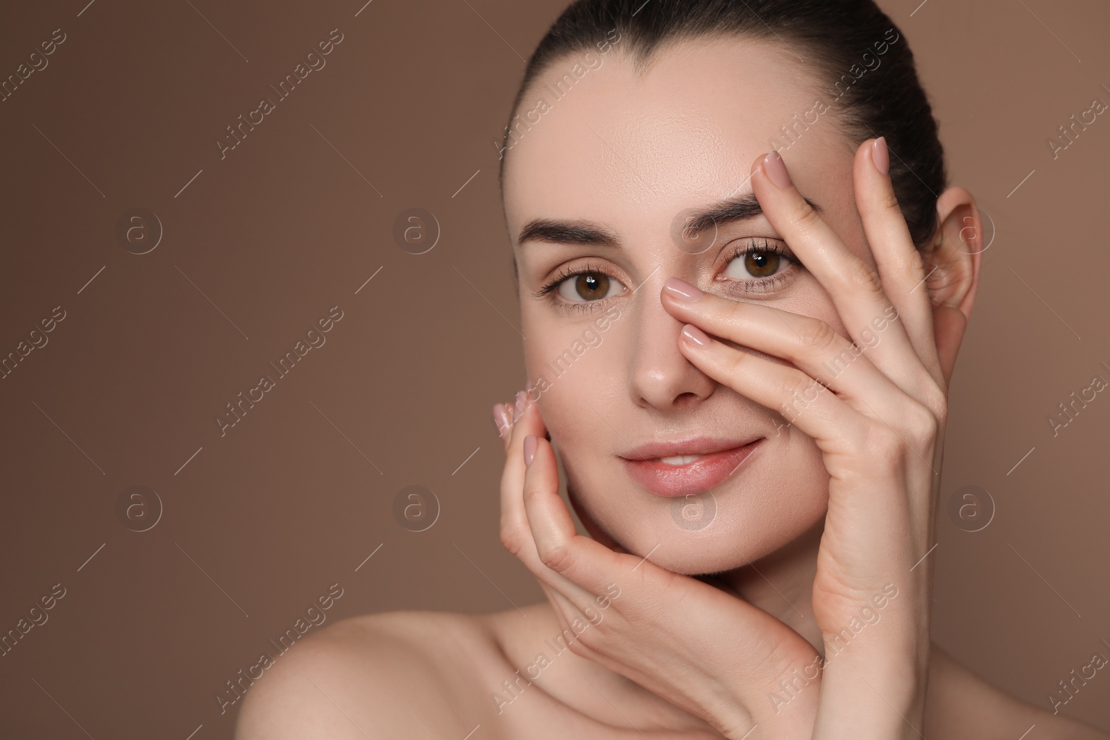 Photo of Portrait of beautiful young woman on brown background. Space for text