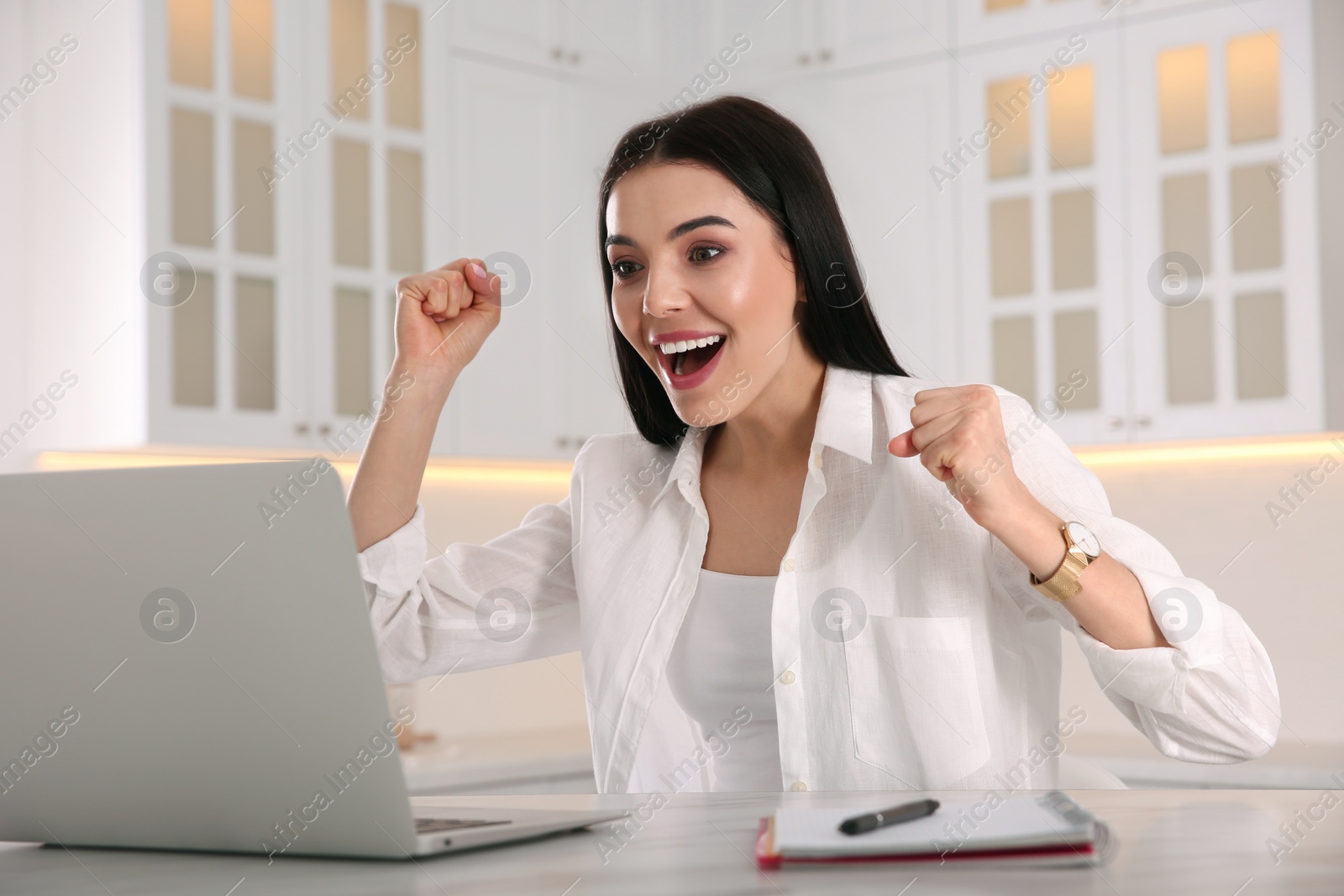 Photo of Emotional woman participating in online auction using laptop at home