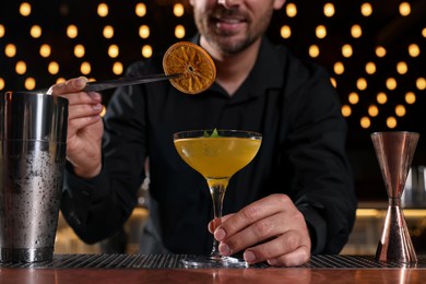 Photo of Bartender preparing fresh alcoholic cocktail in bar, closeup