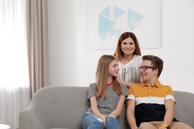 Happy mother with her teenager daughter and son at home