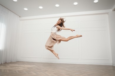 Photo of Beautiful professional dancer practicing moves in studio