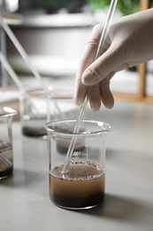 Photo of Scientist preparing soil extract at table, closeup. Laboratory analysis