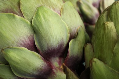 Photo of Fresh raw artichokes as background, closeup view