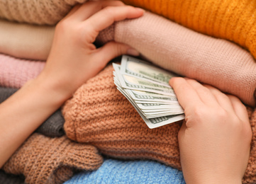 Photo of Woman hiding money between clothes, closeup. Financial savings
