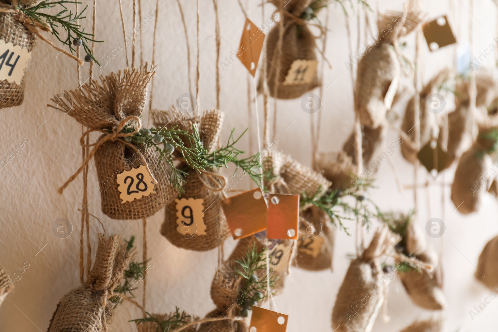 Photo of New Year advent calendar hanging on beige wall indoors, closeup