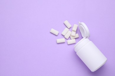 Photo of Jar with chewing gums on lilac background, flat lay. Space for text