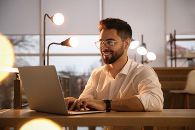 Photo of Man working with laptop at table in office