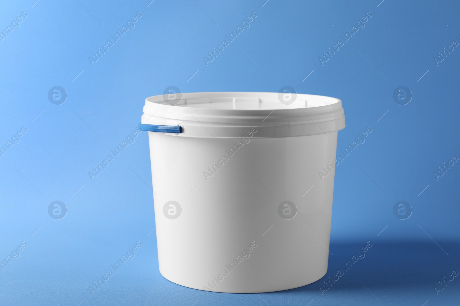 Photo of One plastic bucket with lid on light blue background