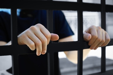 Man detained in jail outdoors, closeup. Criminal law