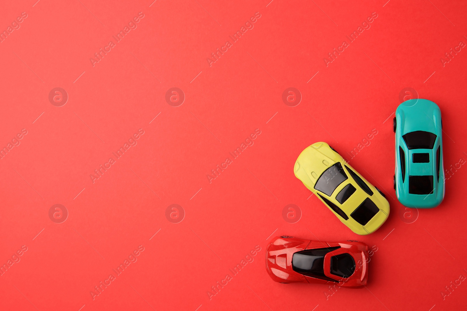 Photo of Different bright cars on red background, flat lay. Space for text