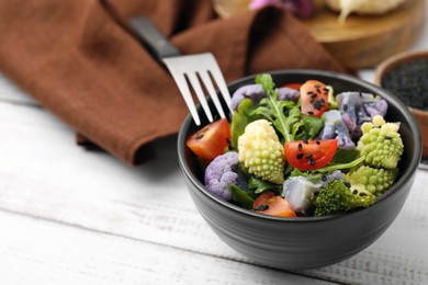 Delicious salad with cauliflower and tomato served on white wooden table, closeup. Space for text