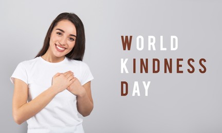 Image of World Kindness Day. Grateful woman pressing hands to chest on grey background, banner design