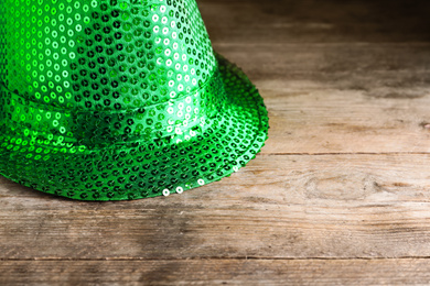 Green leprechaun hat on wooden table, space for text. St. Patrick's Day celebration