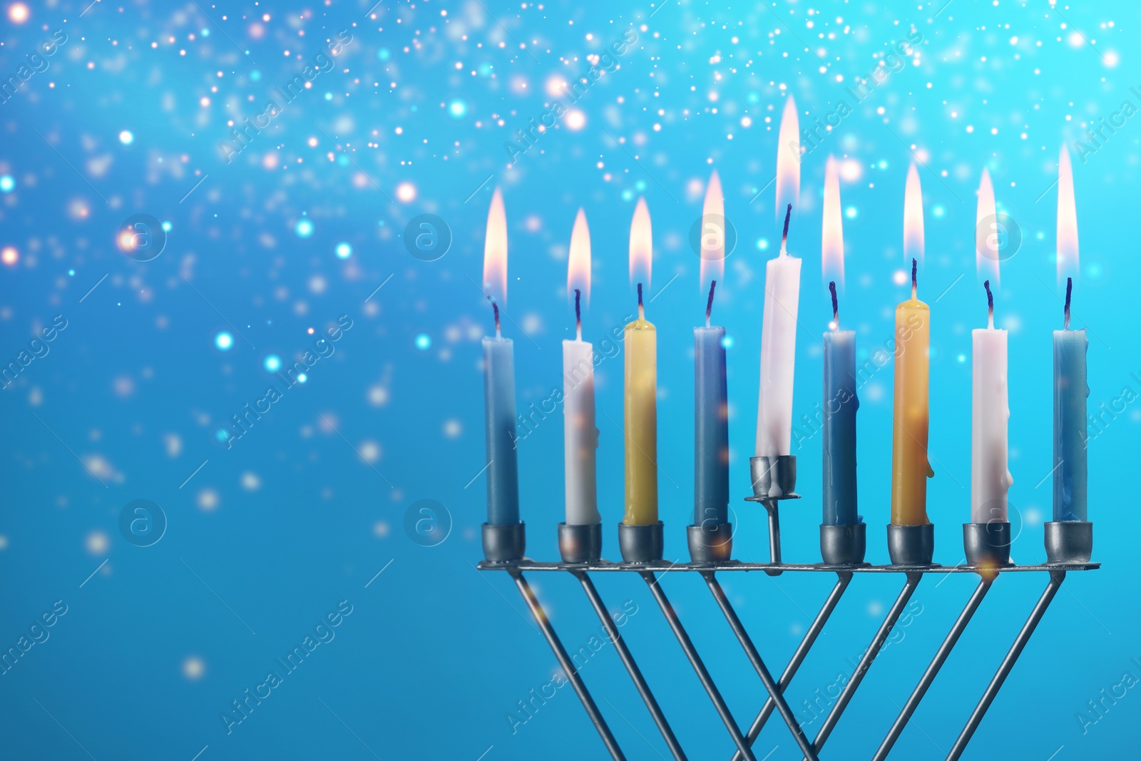 Image of Hanukkah celebration. Menorah with burning candles on light blue background, closeup. Space for text