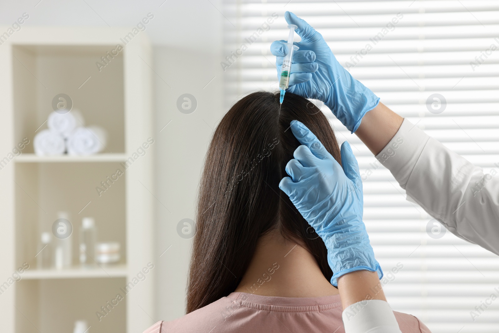 Photo of Trichologist giving injection to patient in clinic, closeup. Space for text