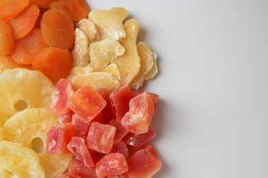 Photo of Pile of different dried fruits on white background, top view. Space for text