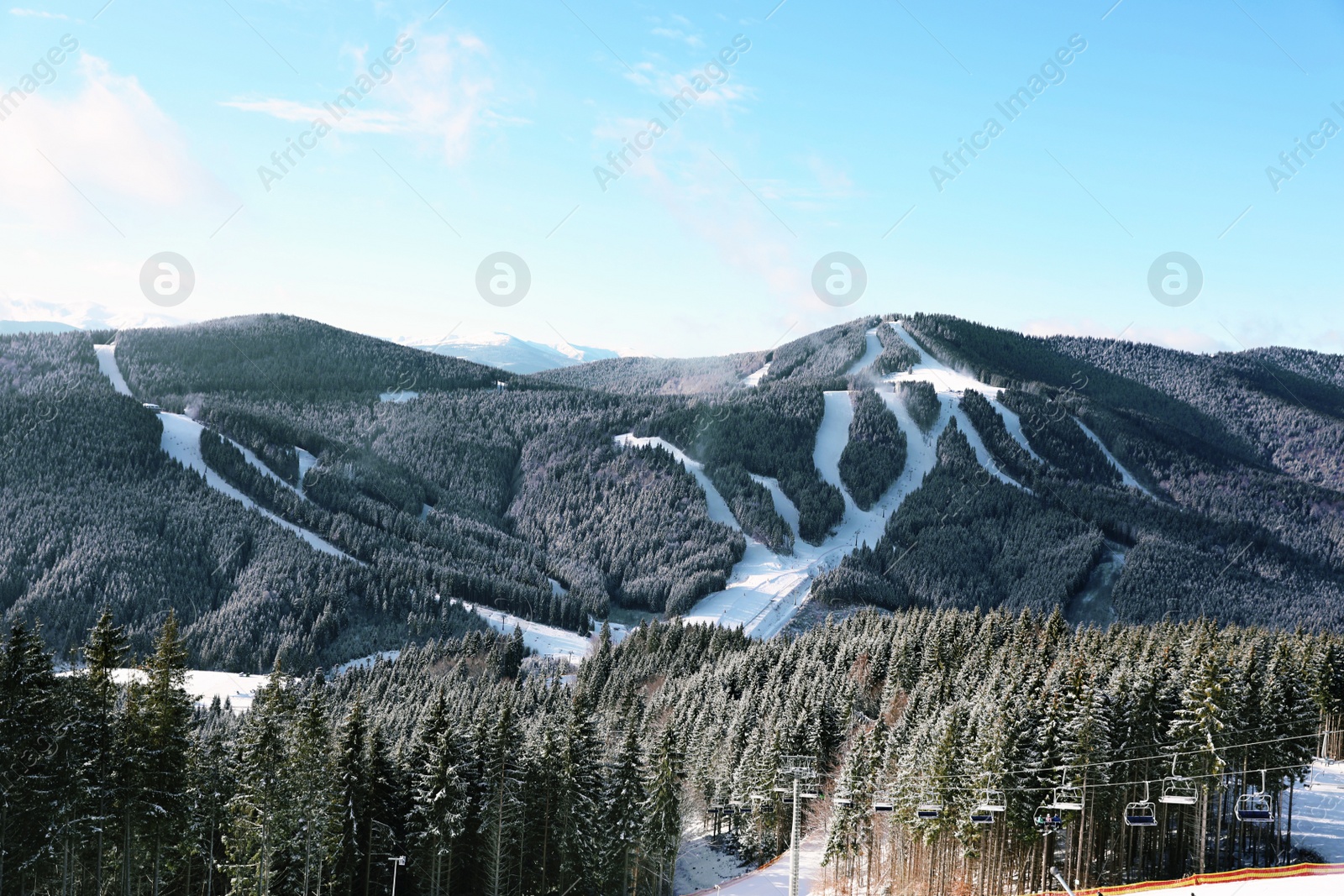 Photo of Beautiful mountain landscape with forest and ski lift on sunny day in winter