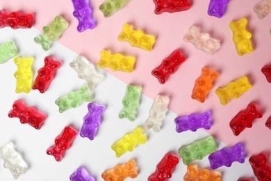 Many delicious little jelly bears on color background, flat lay