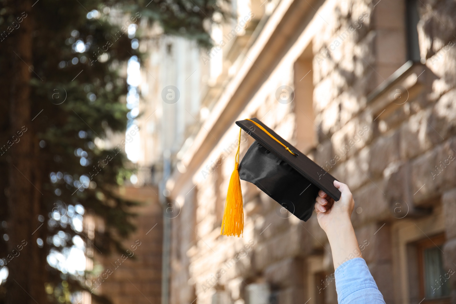 Photo of Student with graduation hat outdoors on sunny day, closeup