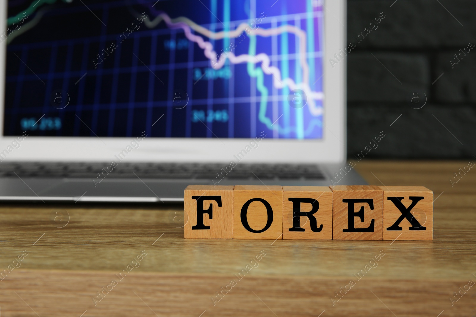 Photo of Word Forex made with cubes and laptop on wooden table