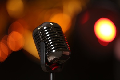 Photo of Retro microphone against festive lights. Musical equipment