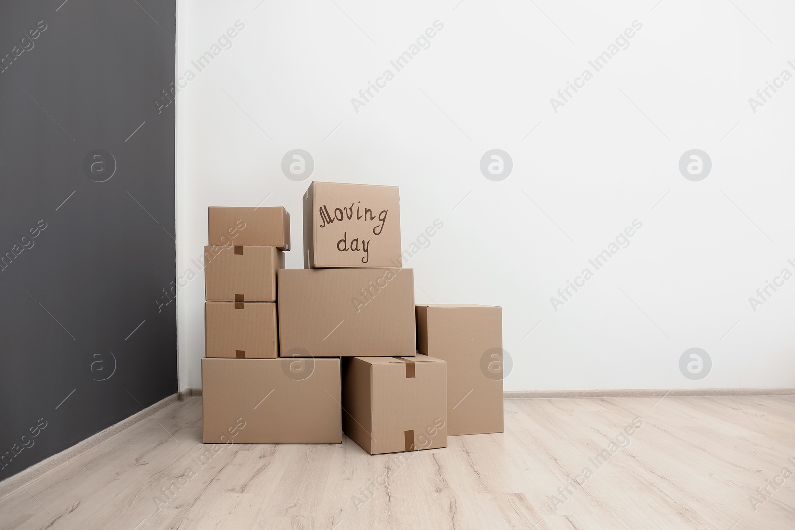 Photo of Pile of moving boxes in empty room