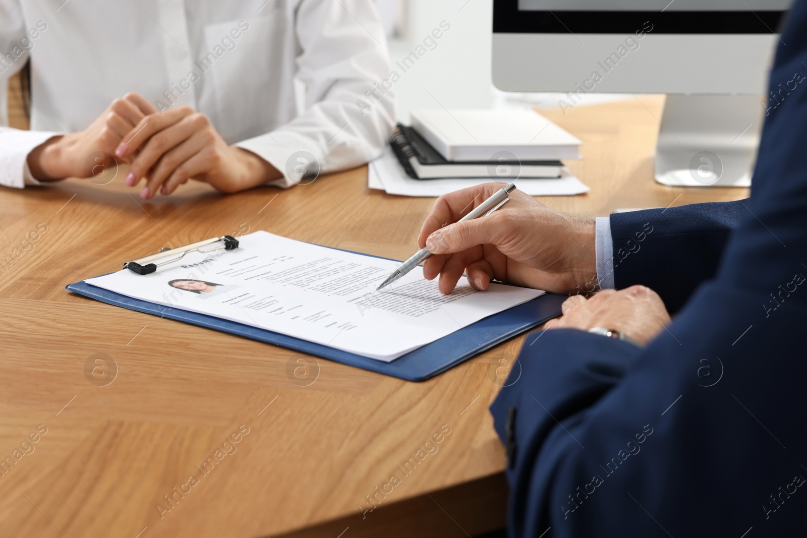 Photo of Human resources manager reading applicant's resume in office, closeup