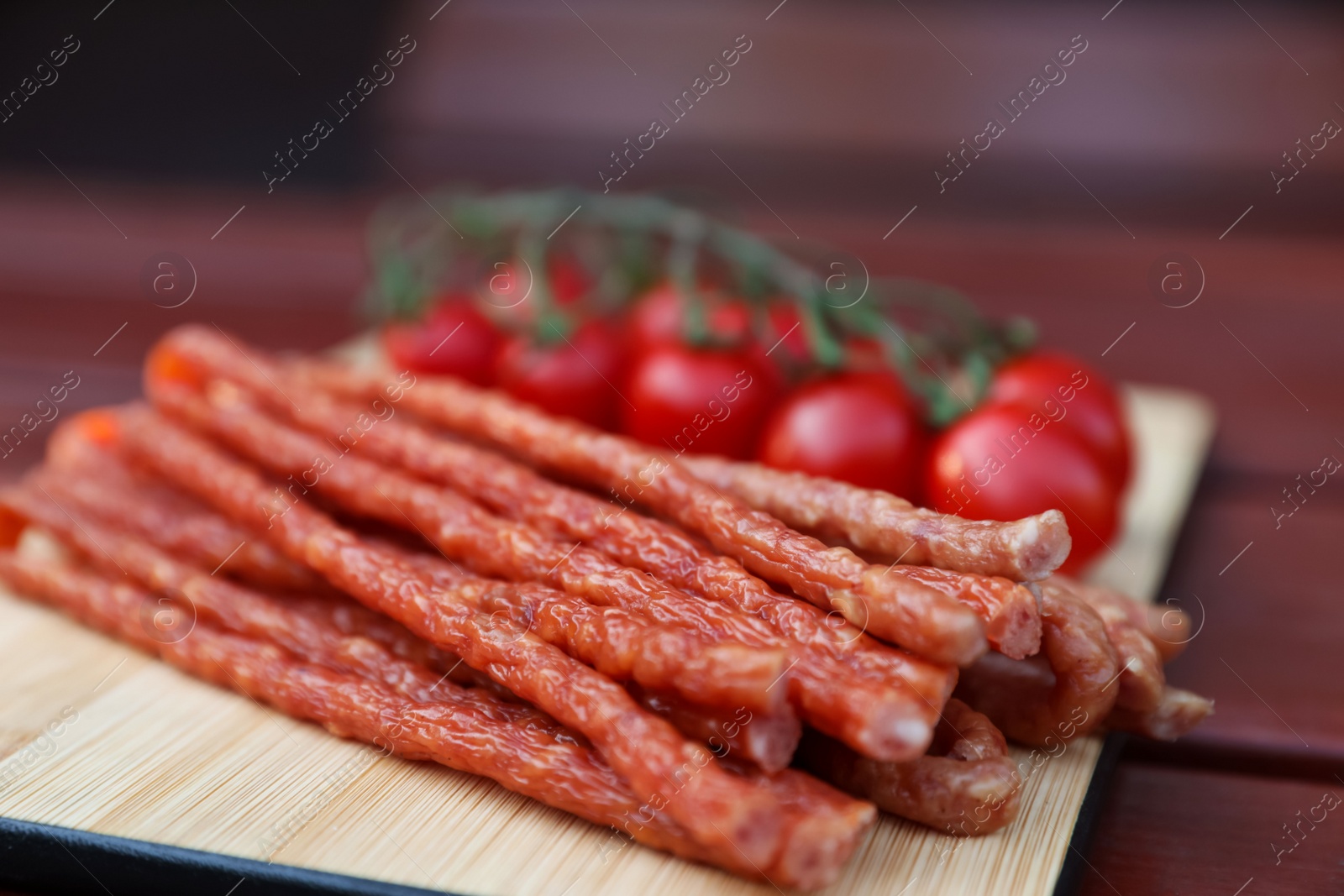 Photo of Tasty dry cured sausages (kabanosy) on wooden table, closeup