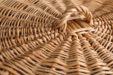 Photo of Lid of handmade wicker basket as background, closeup