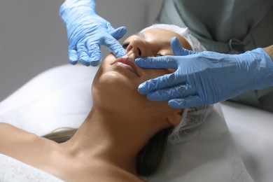 Photo of Young woman receiving facial massage in salon