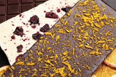 Photo of Different chocolate bars with freeze dried fruits as background, closeup