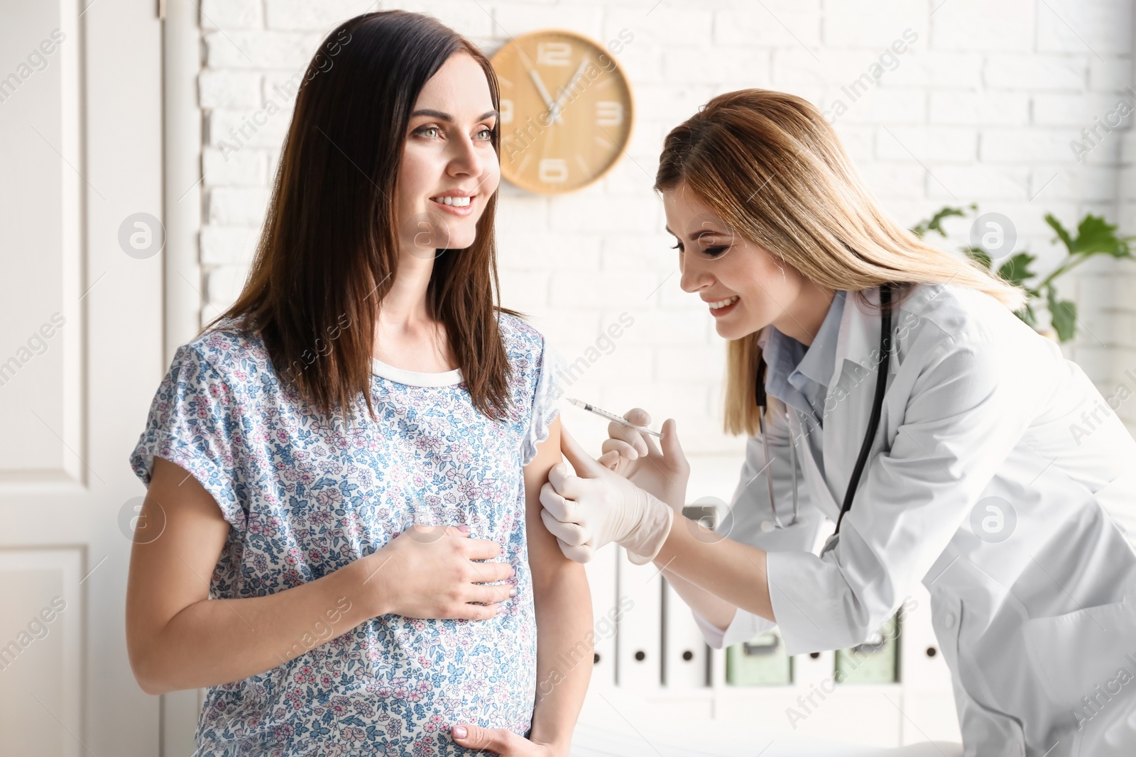 Photo of Doctor vaccinating pregnant woman in clinic