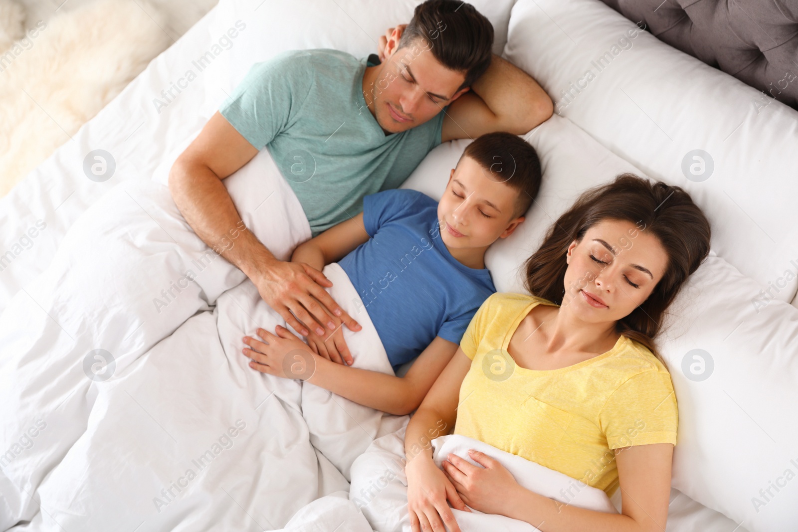 Photo of Portrait of young family sleeping in bed, above view