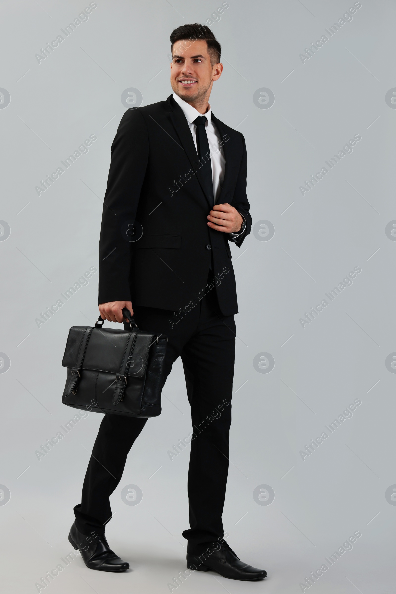 Photo of Businessman with stylish leather briefcase on light background