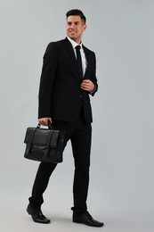 Businessman with stylish leather briefcase on light background