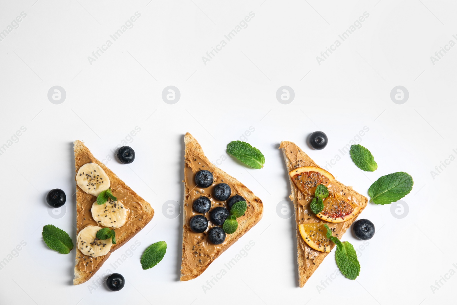 Photo of Different toasts with fruits, blueberries, peanut butter and chia seeds on white background, top view. Space for text