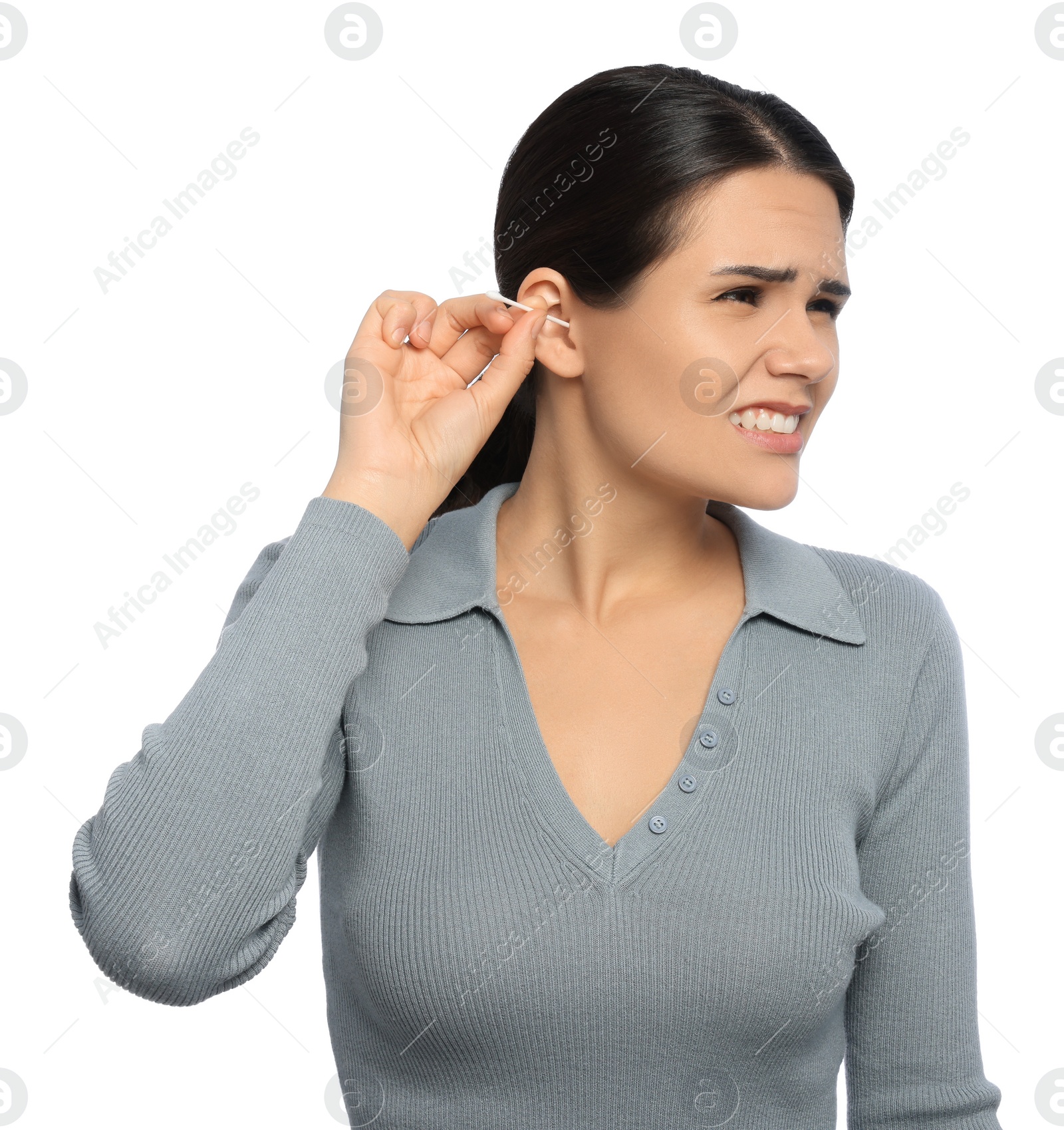 Photo of Young woman cleaning ear with cotton swab on white background