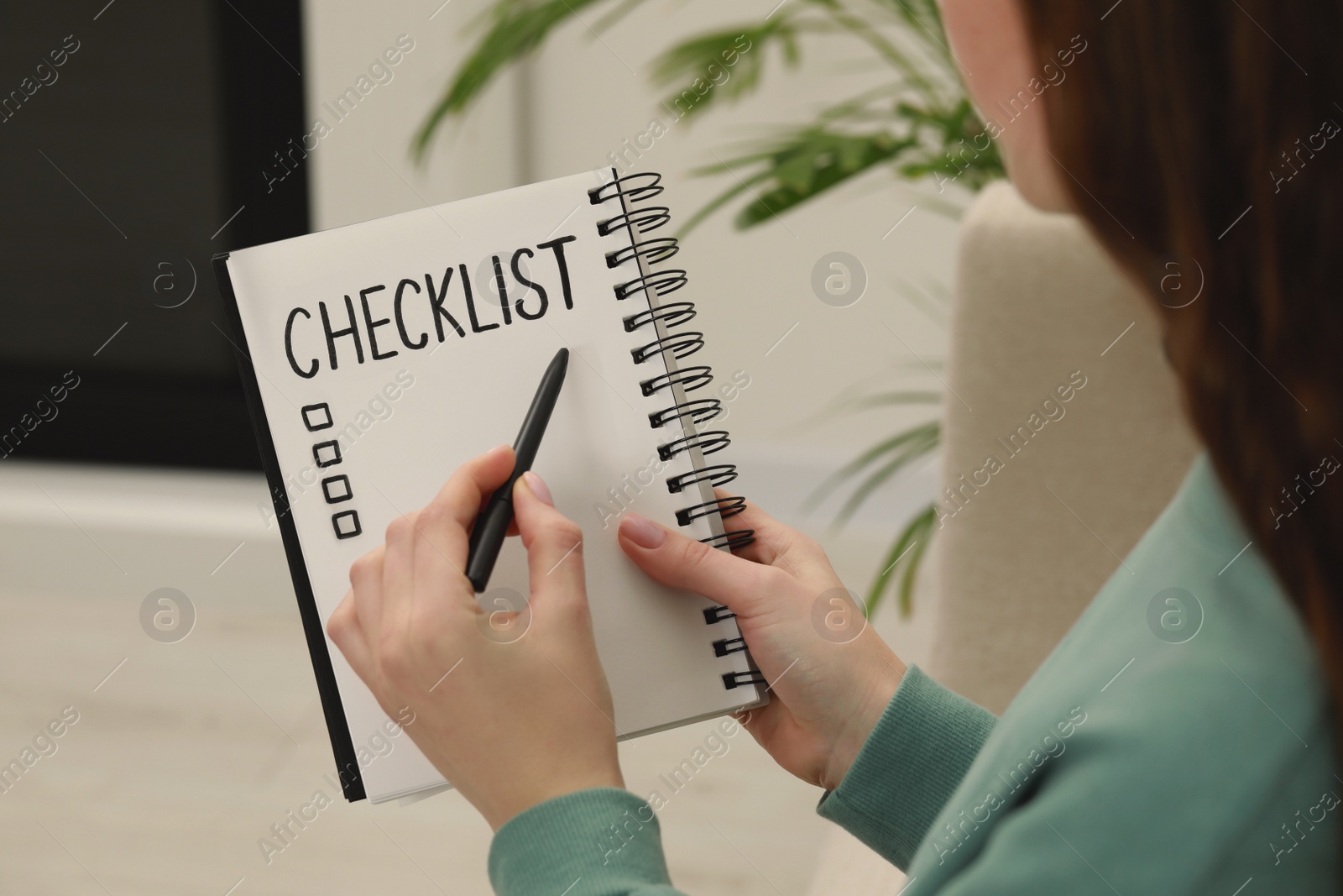 Photo of Woman filling Checklist with pen indoors, closeup