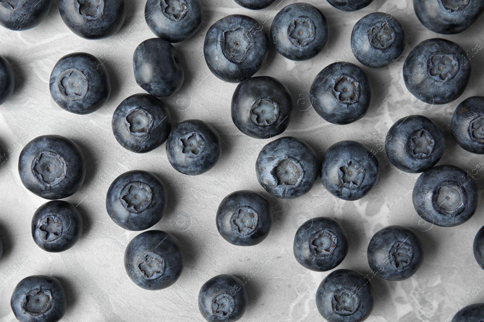 Photo of Tasty fresh blueberries on grey marble table, top view