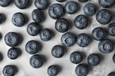 Tasty fresh blueberries on grey marble table, top view