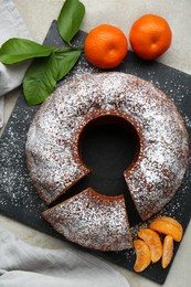 Photo of Delicious homemade yogurt cake with tangerines and powdered sugar on gray table, flat lay