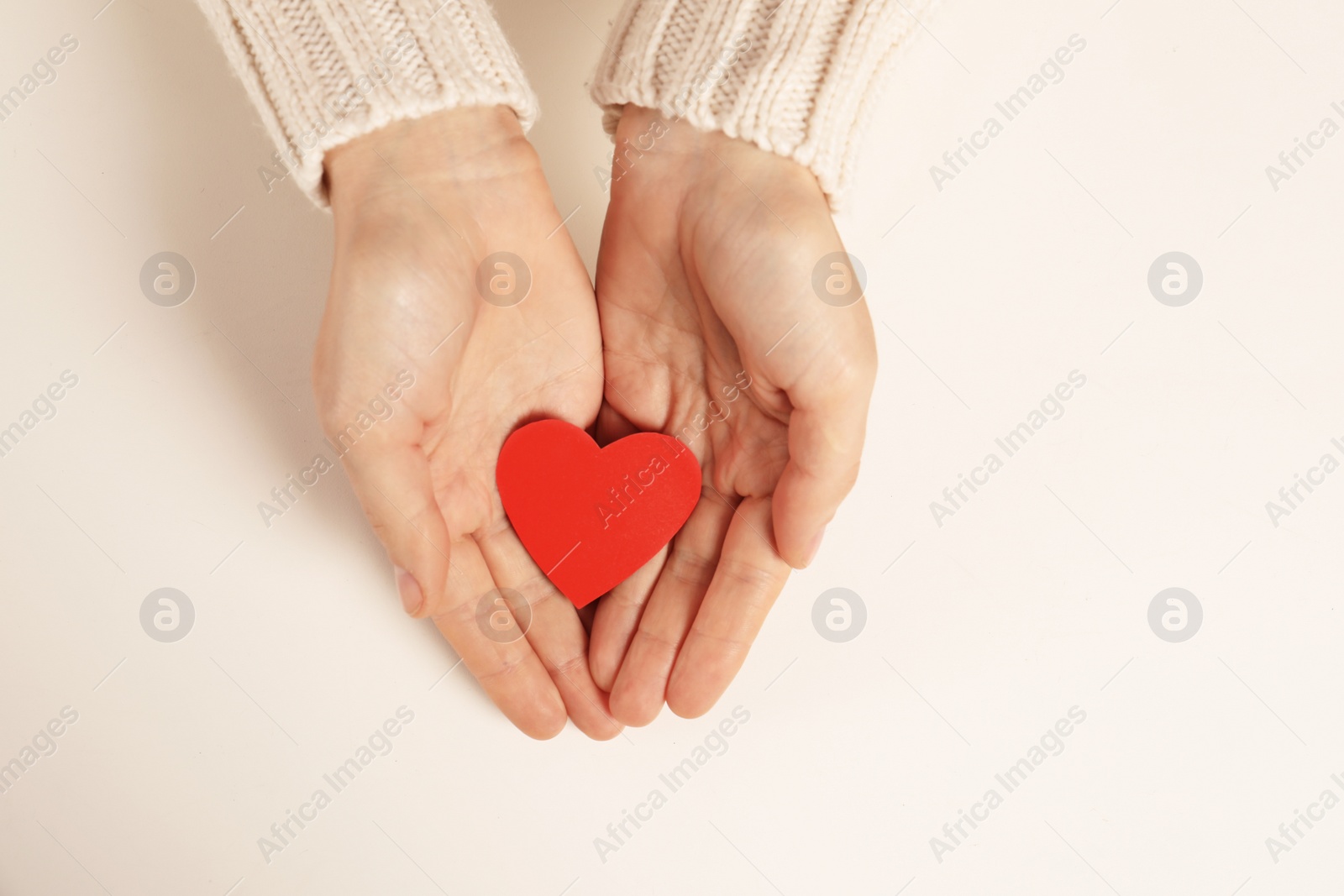 Photo of Woman holding paper heart on white background, top view with space for text