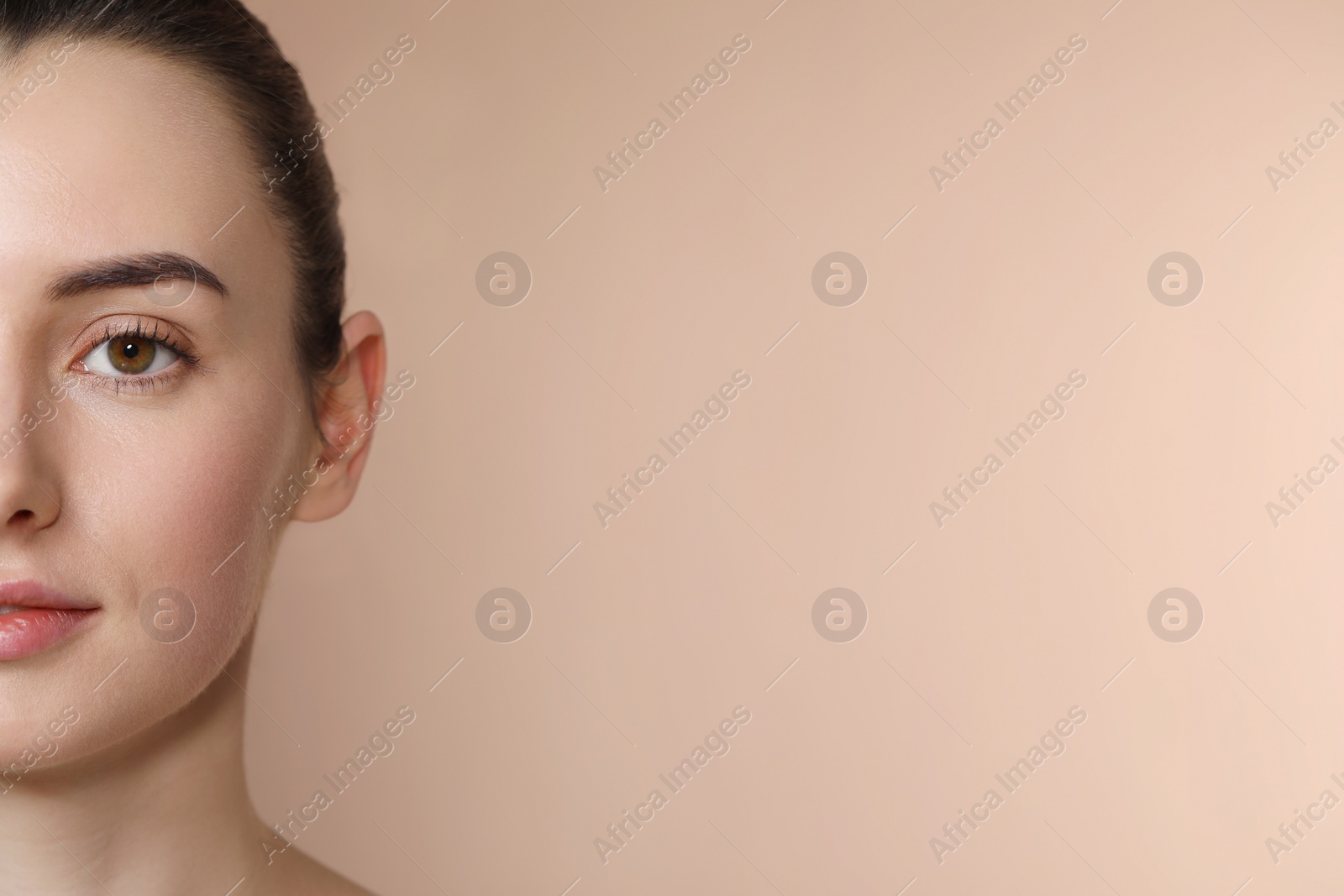 Photo of Beautiful young woman with healthy skin on light brown background, closeup. Space for text