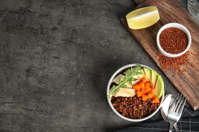 Red quinoa with garnish in bowl on table, top view. Space for text