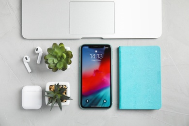 MYKOLAIV, UKRAINE - JULY 10, 2020: Flat lay composition with Iphone 11, MacBook laptop and AirPods on grey table