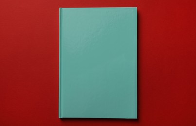 Photo of New stylish planner with hard cover on red background, top view